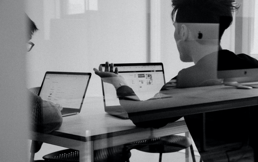 pessoas trabalhando no computador e conversando sobre feedback