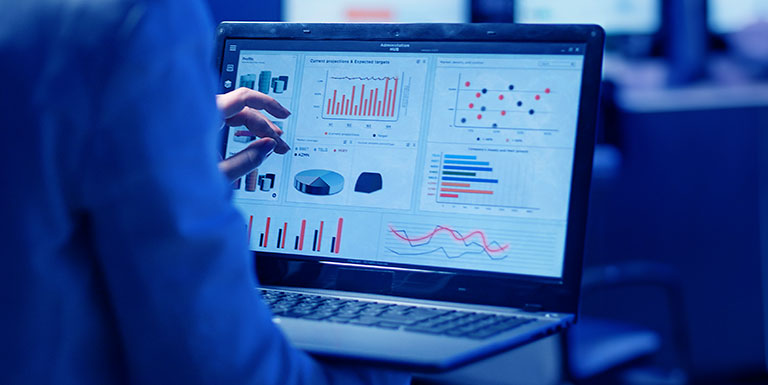 uma pessoa mexendo no notebook em um dashboard, mostrando a maturidade analítica da empresa que trabalha